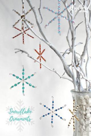 snowflakes made with beads and wires hang from a white tree branch